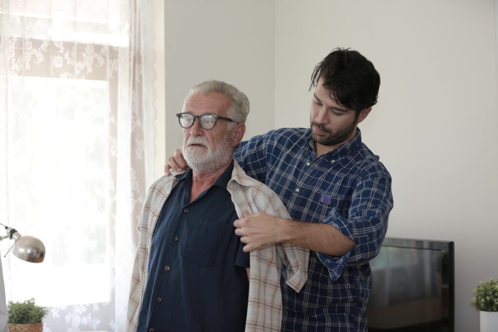 A young adult son assists his elderly father at home, showcasing care and support. Can a grown child collect parents' Social Security? Learn about eligibility and benefits.